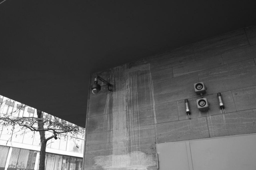 Security cameras mounted on a stone building exterior, relevant to business CCTV installation rules