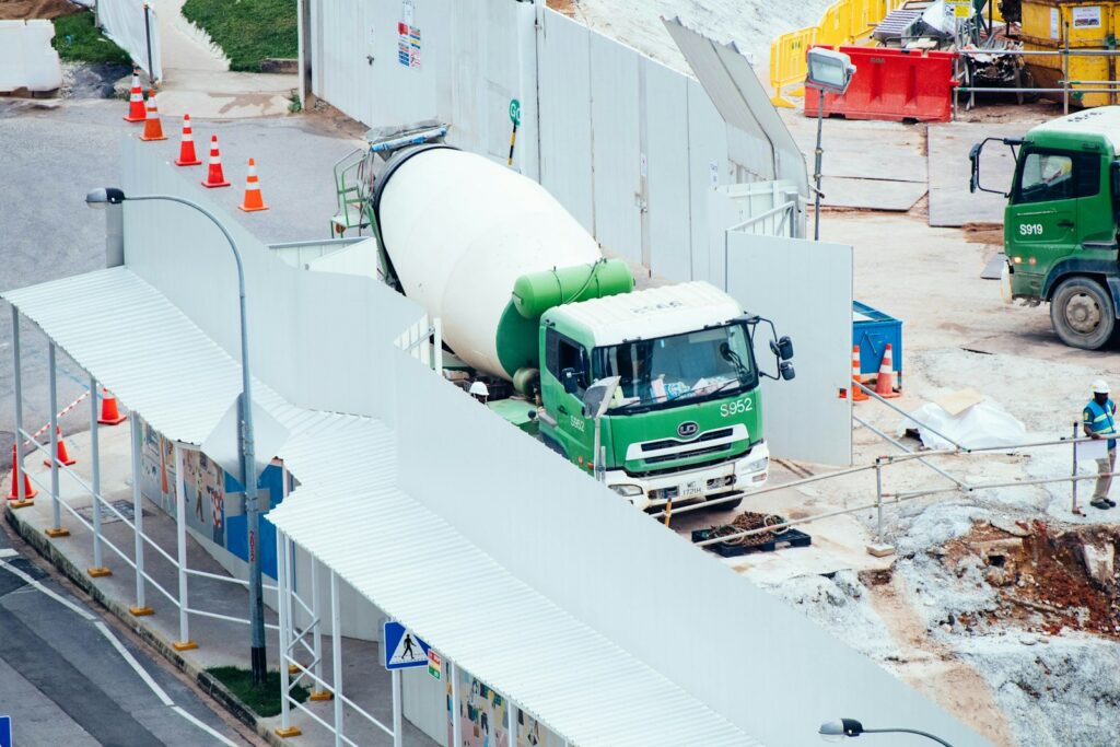 Green and white mixer truck at a construction site